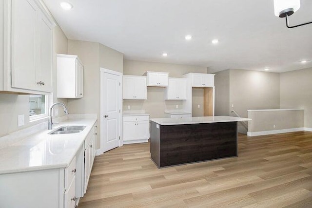 6218 Sturgeon Run, Muskegon, MI 49444 - kitchen featuring a sink, a center island, light wood-type flooring, white cabinetry, and recessed lighting