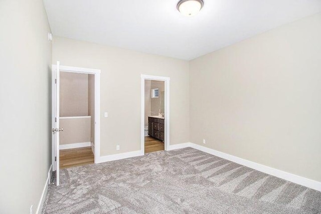 6218 Sturgeon Run, Muskegon, MI 49444 - unfurnished bedroom featuring carpet floors, baseboards, and connected bathroom