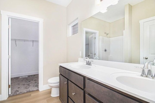 6218 Sturgeon Run, Muskegon, MI 49444 - full bathroom with toilet, wood finished floors, a shower, double vanity, and a spacious closet