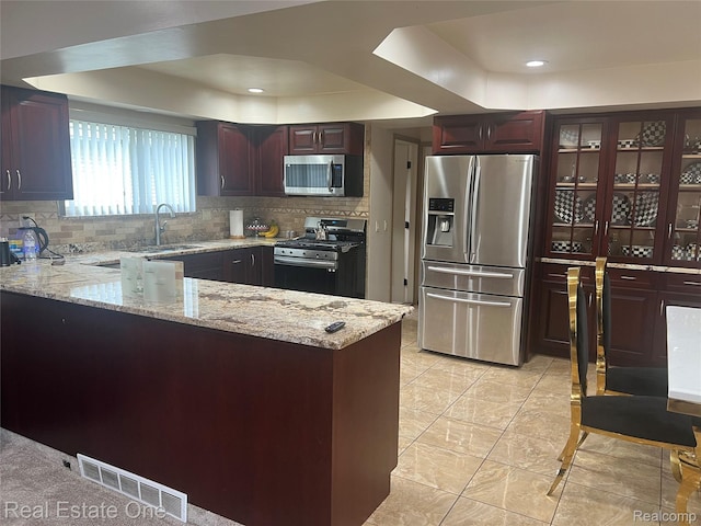 35715 Maureen Dr, Sterling Heights, MI 48310 - kitchen featuring stainless steel appliances, a raised ceiling, a sink, a peninsula, and decorative backsplash