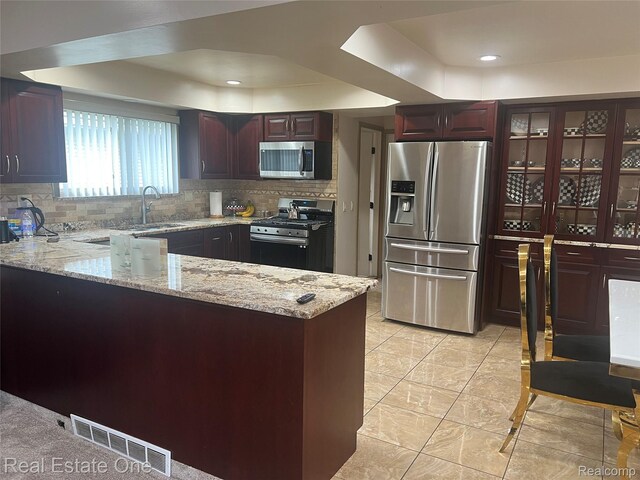 35715 Maureen Dr, Sterling Heights, MI 48310 - kitchen featuring stainless steel appliances, a raised ceiling, a sink, a peninsula, and decorative backsplash