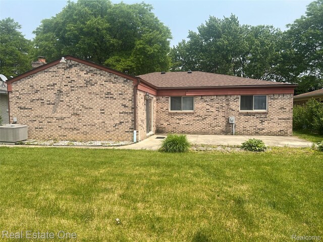 35715 Maureen Dr, Sterling Heights, MI 48310 - view of front of house with a patio, cooling unit, brick siding, and a front yard