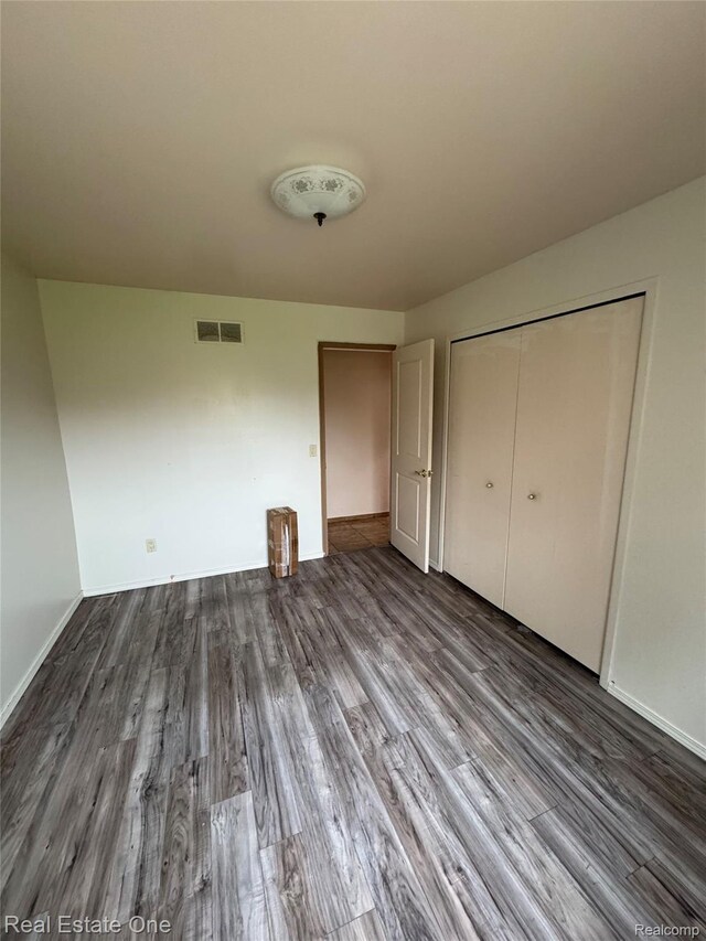 35715 Maureen Dr, Sterling Heights, MI 48310 - unfurnished bedroom with dark wood finished floors, baseboards, and a closet