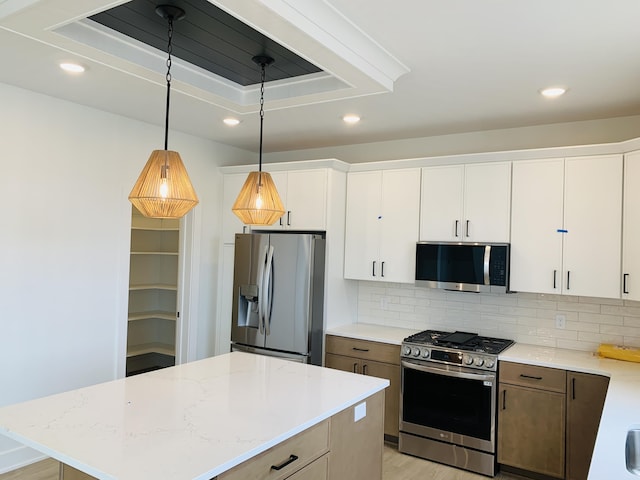 15765 Norwalk Rd, Grand Haven, MI 49417 - kitchen with appliances with stainless steel finishes, recessed lighting, tasteful backsplash, white cabinets, and hanging light fixtures