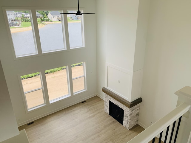 15765 Norwalk Rd, Grand Haven, MI 49417 - unfurnished living room featuring light wood-style floors, a ceiling fan, plenty of natural light, a water view, and a towering ceiling