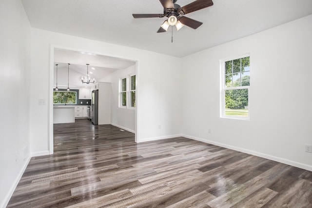 103 W Pearl St, Marshall, MI 49068 - unfurnished living room featuring a chandelier, dark wood-style flooring, ceiling fan, and baseboards