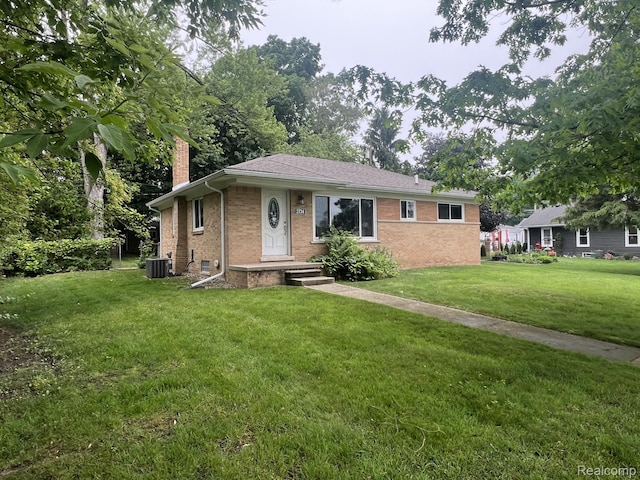 2734 Lakeridge, Wixom, MI 48393 - single story home featuring a chimney, a front lawn, brick siding, and central AC unit
