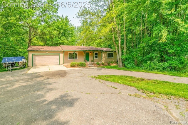 22850 Sumpter Rd, Belleville, MI 48111 - view of front of house featuring driveway, a garage, and a porch