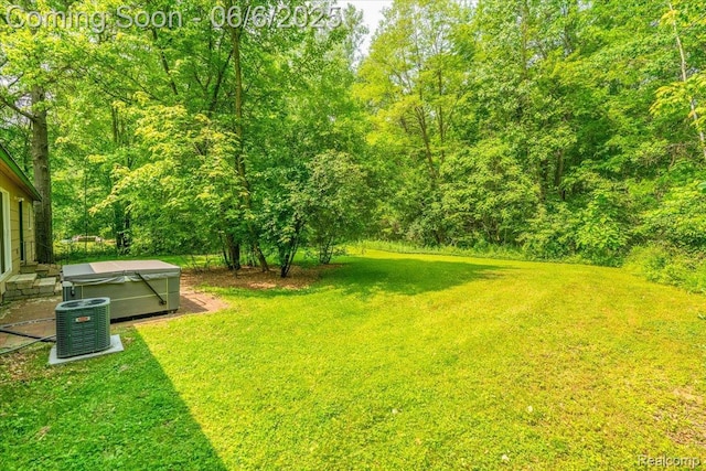 22850 Sumpter Rd, Belleville, MI 48111 - view of green lawn with a hot tub and central AC unit