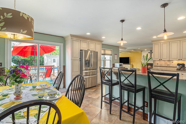 813 Birchwood Dr, Flushing, MI 48433 - kitchen with stainless steel fridge, cream cabinets, recessed lighting, backsplash, and hanging light fixtures
