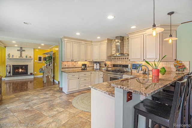 813 Birchwood Dr, Flushing, MI 48433 - kitchen featuring wall chimney range hood, cream cabinetry, high end stove, stone countertops, and tasteful backsplash