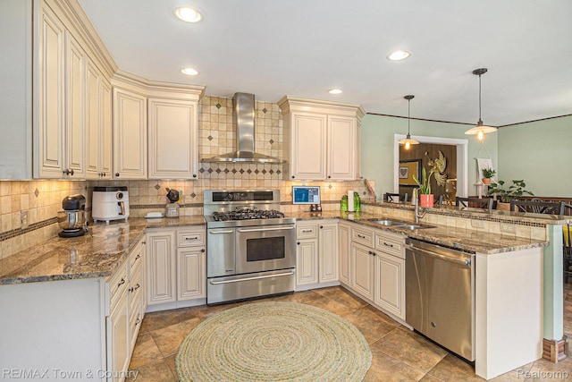 813 Birchwood Dr, Flushing, MI 48433 - kitchen featuring stainless steel appliances, wall chimney exhaust hood, a sink, a peninsula, and tasteful backsplash