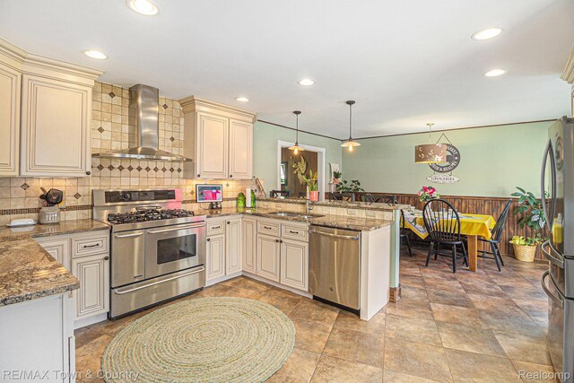 813 Birchwood Dr, Flushing, MI 48433 - kitchen featuring stainless steel appliances, wall chimney exhaust hood, cream cabinets, a peninsula, and recessed lighting