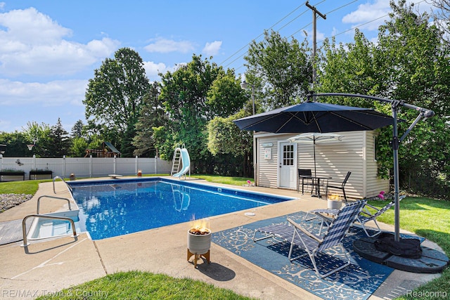 813 Birchwood Dr, Flushing, MI 48433 - view of swimming pool featuring an outdoor structure, a storage structure, a water slide, and a patio area