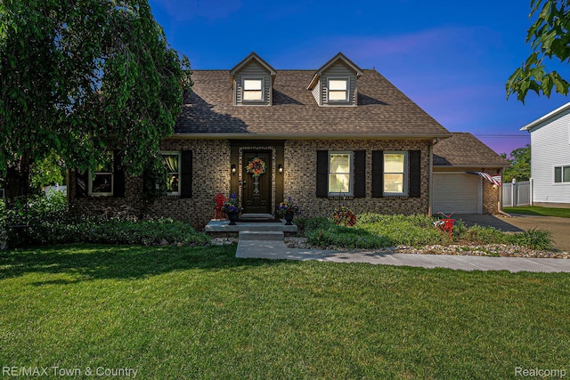813 Birchwood Dr, Flushing, MI 48433 - new england style home with brick siding, an attached garage, a yard, driveway, and roof with shingles
