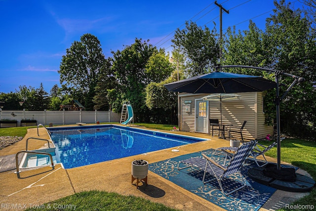 813 Birchwood Dr, Flushing, MI 48433 - view of pool with an outbuilding, a water slide, a patio, and a storage structure