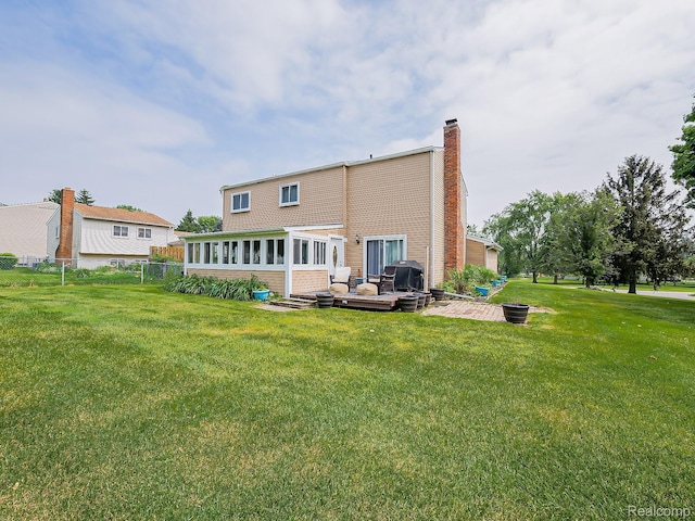 1725 Windingway Dr, Wixom, MI 48393 - rear view of house with a chimney, a lawn, and a patio area