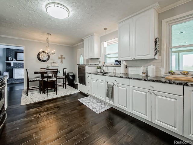 1725 Windingway Dr, Wixom, MI 48393 - kitchen featuring dark wood finished floors, a chandelier, white cabinetry, a textured ceiling, and ornamental molding