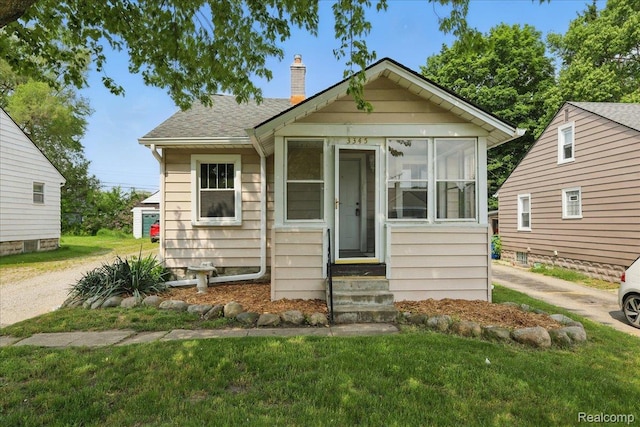 3345 Curwood St, Bloomfield Hills, MI 48329 - bungalow-style home featuring a chimney, entry steps, a sunroom, a front yard, and roof with shingles