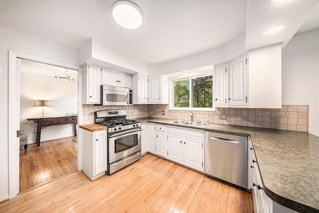 2402 Victoria Ave, Ann Arbor, MI 48104 - kitchen with appliances with stainless steel finishes, a sink, white cabinetry, and tasteful backsplash