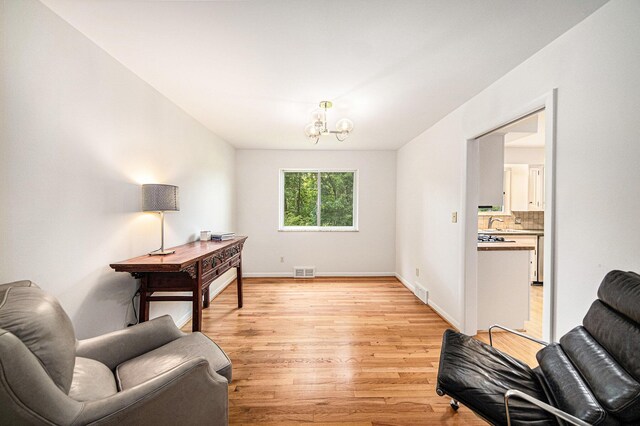 2402 Victoria Ave, Ann Arbor, MI 48104 - sitting room with light wood-type flooring, a chandelier, and baseboards