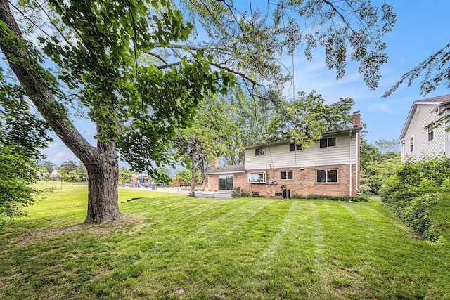 2402 Victoria Ave, Ann Arbor, MI 48104 - back of property with brick siding, a yard, and a chimney