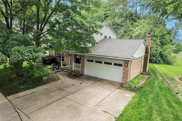 2402 Victoria Ave, Ann Arbor, MI 48104 - view of front facade with driveway, brick siding, a front lawn, an attached garage, and a chimney