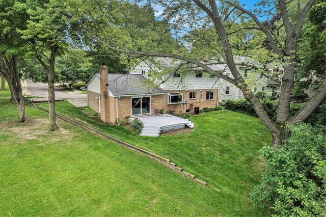 2402 Victoria Ave, Ann Arbor, MI 48104 - rear view of house with brick siding, a chimney, a yard, and a wooden deck