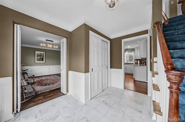 100 Overhill Rd, Bloomfield Hills, MI 48301 - entryway featuring light marble finish floors, a wainscoted wall, a decorative wall, and stairway