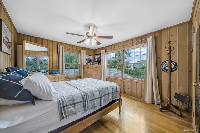 100 Overhill Rd, Bloomfield Hills, MI 48301 - bedroom featuring wood walls, light wood-style floors, and a ceiling fan
