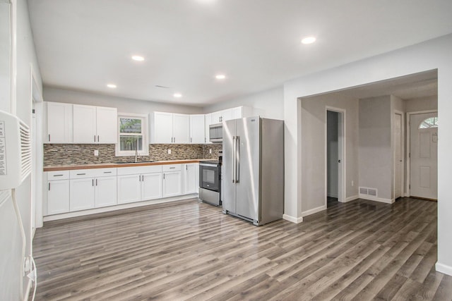 854 Upton Ave, Battle Creek, MI 49037 - kitchen with appliances with stainless steel finishes, butcher block counters, a sink, decorative backsplash, and light wood-style floors