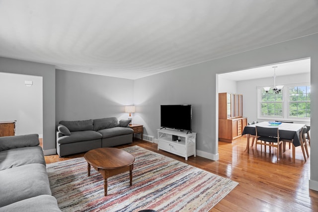 2961 E B Ave, Plainwell, MI 49080 - living room featuring a chandelier, light wood-style flooring, and baseboards