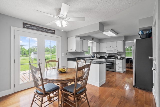 2961 E B Ave, Plainwell, MI 49080 - dining area featuring healthy amount of natural light, light wood-style flooring, a textured ceiling, and a ceiling fan