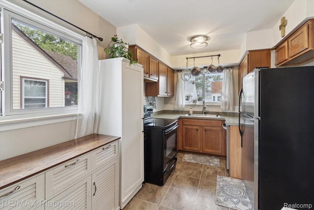13471 Longtin St, Southgate, MI 48195 - kitchen featuring stainless steel appliances, a sink, brown cabinets, and light tile patterned floors