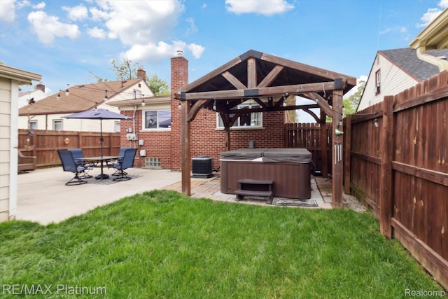 13471 Longtin St, Southgate, MI 48195 - rear view of property featuring a hot tub, a gazebo, brick siding, a chimney, and a patio