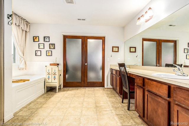 1653 Crab Apple Dr, Ypsilanti, MI 48198 - bathroom featuring french doors, vanity, and a garden tub