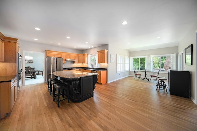 4251 Fleming Way, Plymouth, MI 48170 - kitchen featuring light wood finished floors, a kitchen bar, appliances with stainless steel finishes, a kitchen island, and under cabinet range hood