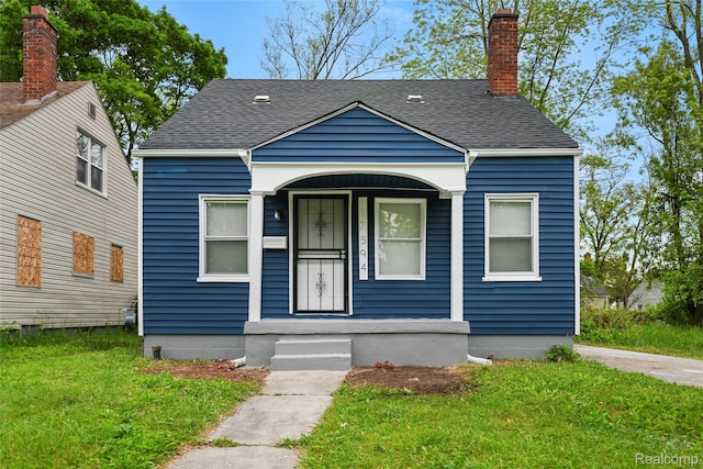 17594 Vaughan St, Detroit, MI 48219 - bungalow-style house featuring a shingled roof, a front lawn, a chimney, and a porch