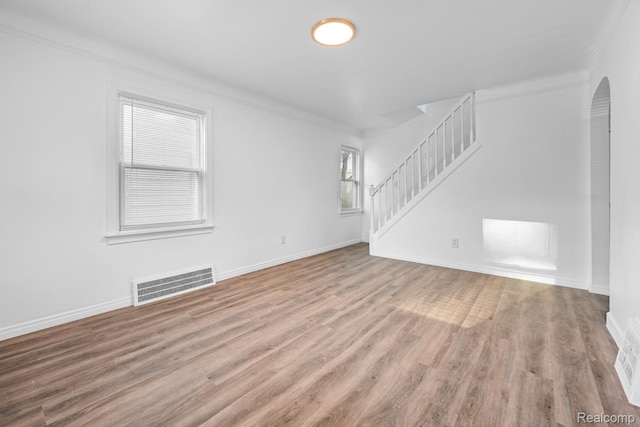 17594 Vaughan St, Detroit, MI 48219 - unfurnished living room featuring wood finished floors, stairs, baseboards, arched walkways, and ornamental molding