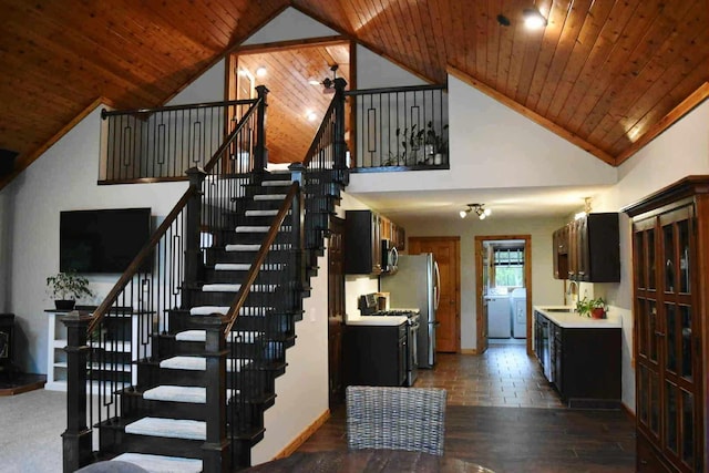 2735 Nestrom Rd, Muskegon, MI 49445 - stairs with wooden ceiling, wood finished floors, high vaulted ceiling, washer and clothes dryer, and baseboards