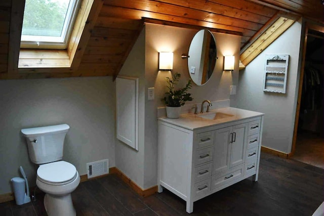 2735 Nestrom Rd, Muskegon, MI 49445 - bathroom with a skylight, vanity, toilet, wood finished floors, and baseboards