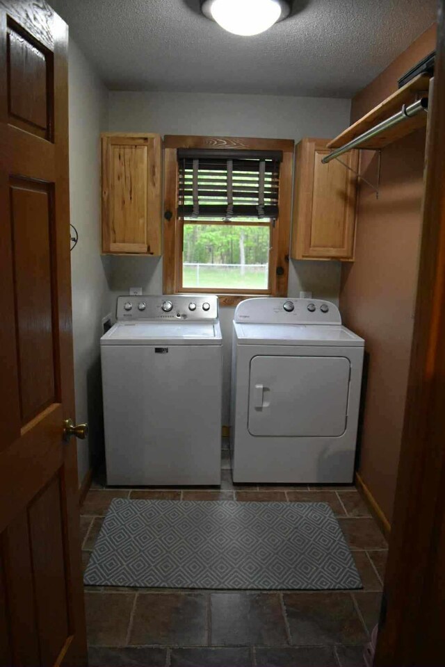 2735 Nestrom Rd, Muskegon, MI 49445 - washroom featuring cabinet space, separate washer and dryer, a textured ceiling, and baseboards