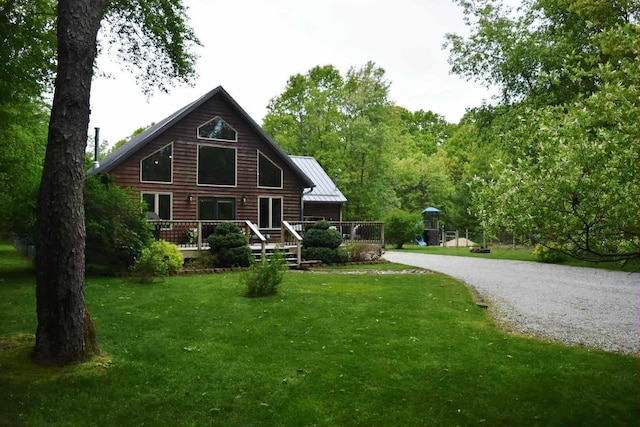 2735 Nestrom Rd, Muskegon, MI 49445 - back of property with a yard, a wooden deck, gravel driveway, and metal roof