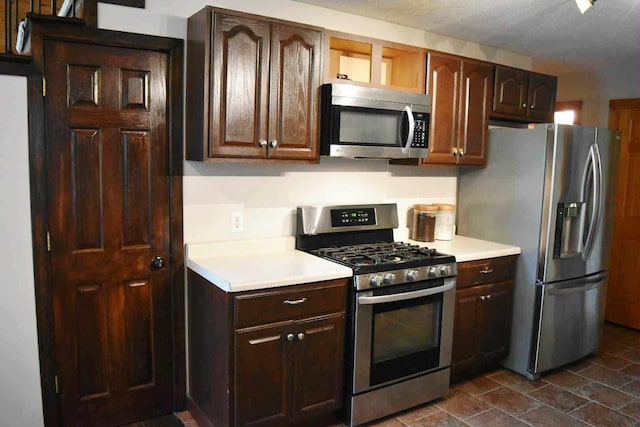 2735 Nestrom Rd, Muskegon, MI 49445 - kitchen with stainless steel appliances, light countertops, and dark brown cabinetry