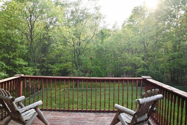2735 Nestrom Rd, Muskegon, MI 49445 - wooden deck featuring a lawn and a wooded view