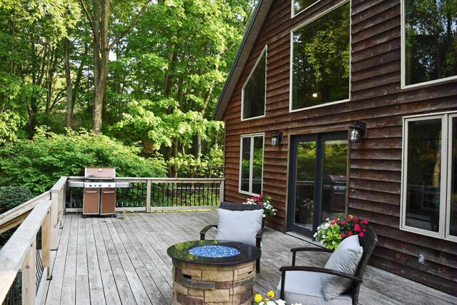 2735 Nestrom Rd, Muskegon, MI 49445 - wooden deck with a fire pit and area for grilling
