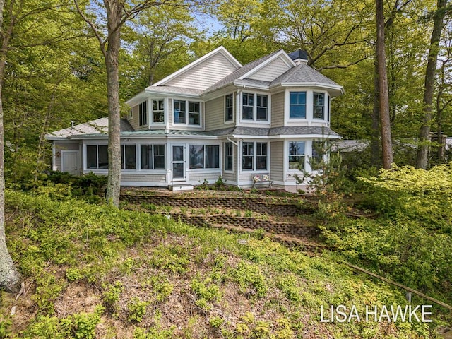 12857 Wilderness Trl, Grand Haven, MI 49417 - victorian home featuring roof with shingles, a sunroom, and a chimney
