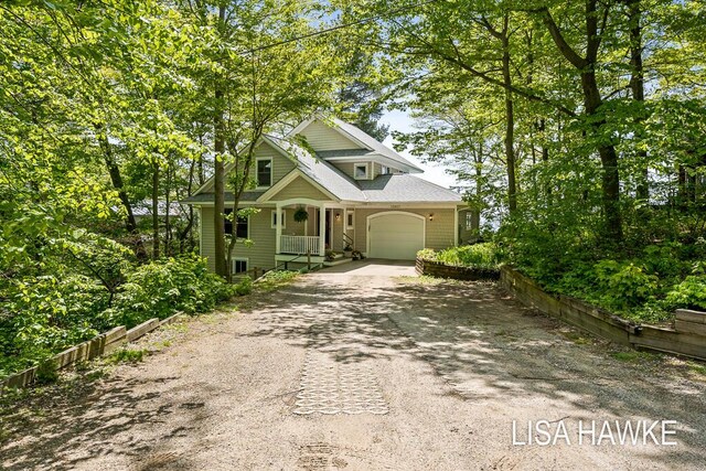 12857 Wilderness Trl, Grand Haven, MI 49417 - view of front of property with dirt driveway, a porch, and a garage