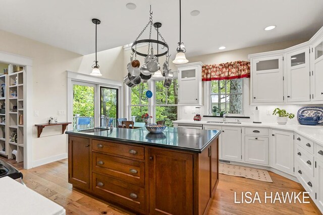 12857 Wilderness Trl, Grand Haven, MI 49417 - kitchen with a sink, a kitchen island, light wood finished floors, white cabinets, and recessed lighting