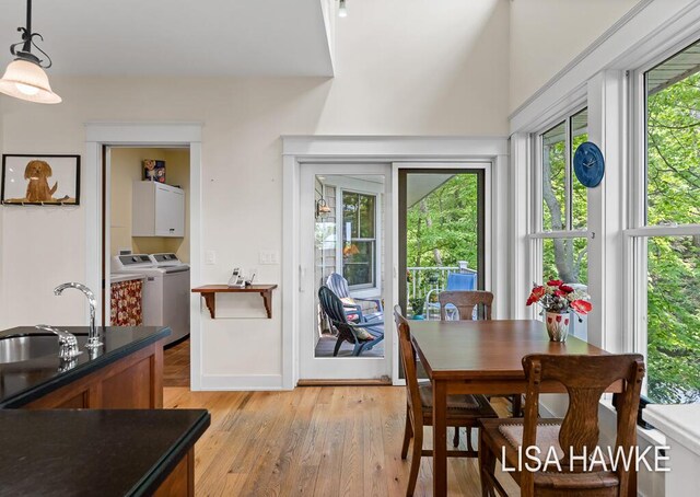 12857 Wilderness Trl, Grand Haven, MI 49417 - dining space featuring washing machine and dryer, light wood-style floors, and baseboards